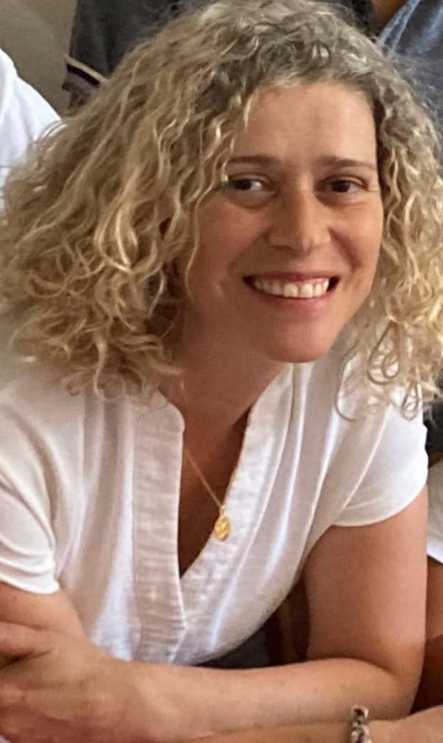 Luisa, a warm and compassionate family coach and mother of 10, smiling gently at the camera